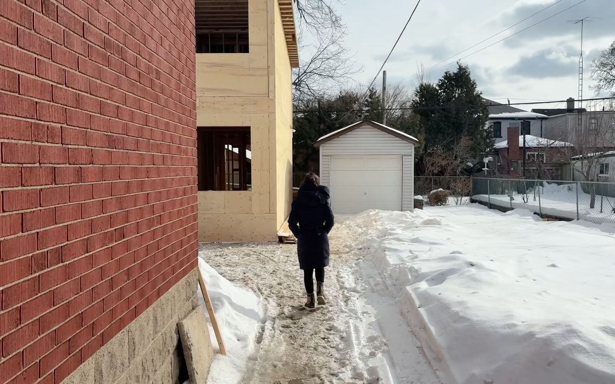 A backyard house under construction behind a Toronto multiplex